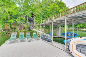 a dock with chairs and a boat on the water at Upscale Getaway on Smith Lake with Boat Dock in Arley