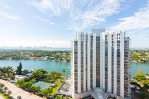 uma vista aérea de um edifício alto e branco próximo a um corpo d'água em Girasole Apartments em Miami Beach
