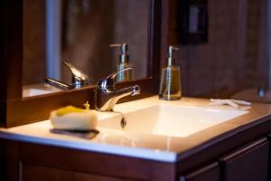 a bathroom sink with a faucet and a mirror at CHALET TENERIFE 5 Estrellas in La Laguna +20 photos