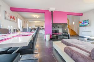 a living room with a dining table and pink walls at Au clair de lune in Saint-Rémy-sous-Barbuise