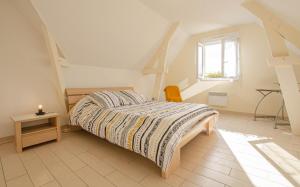 a bedroom with a bed and a table and a window at Au clair de lune in Saint-Rémy-sous-Barbuise