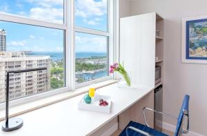 a room with windows and a white counter with a blue chair at MVR Not a normal suite-An Elevated Miami Stay in Miami