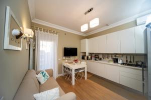 a kitchen and living room with a couch and a table at Charming and Cozy House in Nettuno