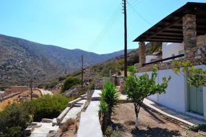a house with a pathway next to a mountain at Theodoti in Agia Theodoti