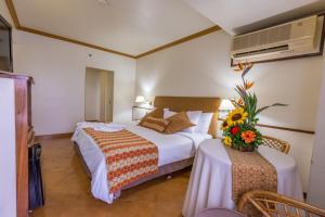 a hotel room with two beds and a vase of flowers at Hotel Olé Caribe in Macuto