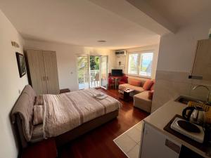 a bedroom with a bed and a living room with a couch at Apartments Smakoski in Ohrid
