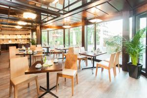 un ristorante con tavoli, sedie e ampie finestre di Trip Inn Klee am Park Wiesbaden a Wiesbaden