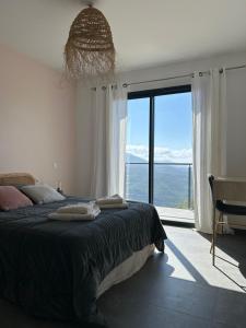 a bedroom with a bed with a view of the ocean at Villa H in Casanova