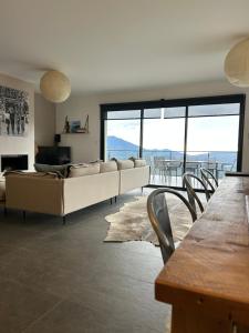 a living room with a couch and a table and chairs at Villa H in Casanova