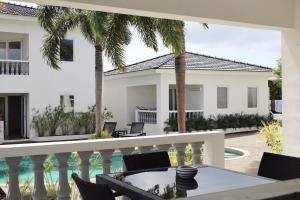 a view of a house from the balcony with a table and chairs at Palm Crest in Willemstad