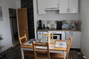 a kitchen with a wooden table with chairs and a table and a table and chairs at ISA ET LIO in Chavanod