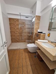 une salle de bains avec douche, toilettes et lavabo dans l'établissement Miriam Apart, à Mamaia Nord – Năvodari