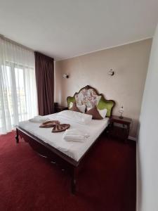 une chambre avec un grand lit avec des draps blancs dans l'établissement Miriam Apart, à Mamaia Nord – Năvodari