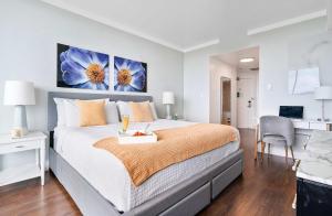 マイアミにあるMVR Suite with Poolside Sips and Biscayne Backdropの壁に青い花の絵が飾られた大きなベッドのある寝室