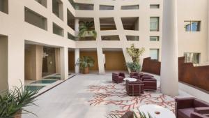 een lobby van een gebouw met paarse stoelen en planten bij Suite la Giudecca by Salento Affitti in Gallipoli