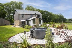 a house with a hot tub in a garden at Highfield Barton in Camborne