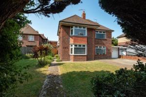 a red brick house with a yard at Westend House in Goring by Sea