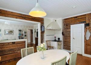 a kitchen and dining room with a white table and chairs at Fyra rum och kök i Mellanfjärden in Mellanfjärden +24 photos