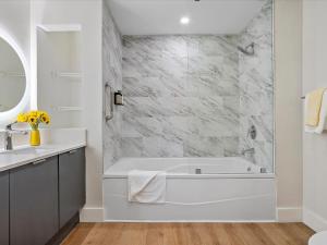 a white bathroom with a tub and a sink at MVR Don-t Miss Out on This Luxury Suite in Miami