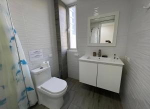 a white bathroom with a toilet and a sink at bavaro Punta Cana Beach club in Punta Cana