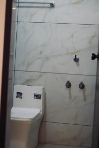 a bathroom with a toilet and a marble wall at AquaTerra Comfy stay Varkala beach in Varkala