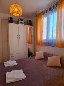 a bedroom with a large bed with orange curtains at Apartman Nenad in Pula