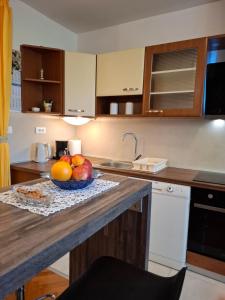 a kitchen with a bowl of fruit on a counter at Apartman Nenad in Pula +4 photos