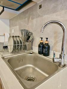 a kitchen sink with two bottles of dishes on it at Condo in Baguio - Megatower 7 Near SM in Baguio