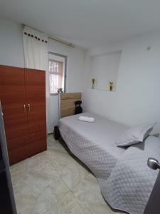 una camera da letto con un letto grande e un armadio in legno di Habitación Privada y Confortable cerca a Centro Mayor y al Centro Histórico a Bogotá