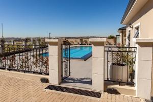 a balcony with a gate and a swimming pool at Closer to Home Luxury Apartments in Midrand