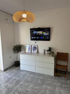 カリテア・ハルキディキにあるAgapi Apartment Kalitheaのリビングルーム(壁にテレビ付)