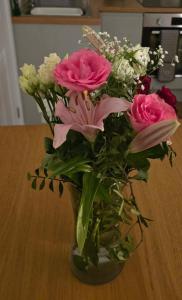 a vase filled with pink and white flowers on a table at Bwthyn Eira in Anglesey +2 photos