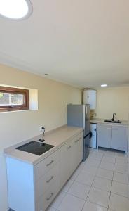 an empty kitchen with a sink and a refrigerator at Refugio Verde Apartamento entero con entrada independiente in Puerto Varas +34 photos