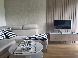 a living room with a couch and a table at Apartament Kasprowy in Kościelisko