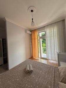una camera da letto con un letto e un paio di pantofole sopra di Temo's guest house in Kvariati a Kvariati