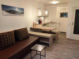 Una sala de estar con un sofá y una cocina. en Ferienwohnung Loitfelder-Pang, en Saalbach Hinterglemm