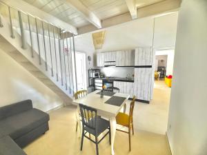 a kitchen and dining room with a table and chairs at Pozzelle Holiday House in Zollino