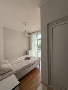 una camera da letto bianca con un letto e una finestra di Temo's guest house in Kvariati a Kvariati