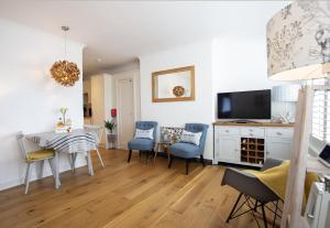 a living room with a table and chairs and a television at Little Jem Harlyn Bay near 7 Bays in Saint Merryn