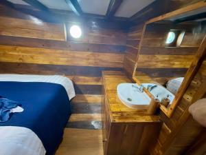 a bathroom with a sink and a bed in a room at Komodo Cruise 3D2N with Emocean Tour - Monday & Friday Departures in Labuan Bajo