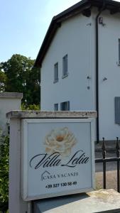 a sign in front of a white building at Pool & Garden Villa Lelia in Mirano