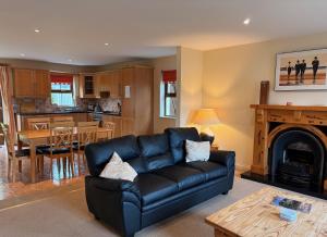 a living room with a black couch and a fireplace at Holiday Home with view of Kenmare Bay Estuary in Kenmare