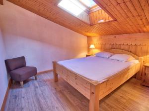 una camera da letto con un letto e una sedia di Charmant duplex rénové, 34 m², 4 pers, vue Mont Charvin - FR-1-505-25 a Notre-Dame-de-Bellecombe