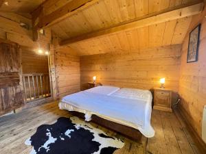 une chambre avec un lit dans une cabane en bois dans l'établissement Mazot savoyard avec 2 chambres, WIFI, animaux admis, parking privatif - FR-1-505-217, à Notre-Dame-de-Bellecombe