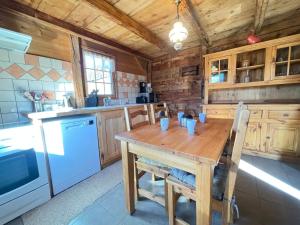 - une cuisine en bois avec une table et des chaises en bois dans l'établissement Mazot savoyard avec 2 chambres, WIFI, animaux admis, parking privatif - FR-1-505-217, à Notre-Dame-de-Bellecombe 18 autres photos