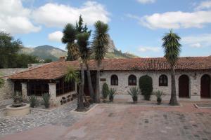 a building with palm trees in front of it at Hotel Casa FERNALI in Bernal