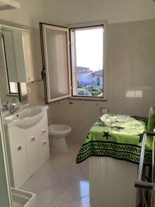 a bathroom with a sink and a bed and a window at BenitiKe House in Cala Gonone