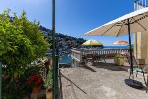a patio with an umbrella and a view of the water at Apartment Mare - Beachfront in Rabac +15 photos