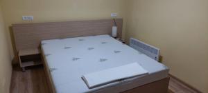a small bedroom with a bed with white sheets at Gabriel in Sofia Rezidence in Saturn