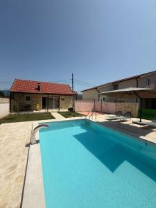 a large blue swimming pool in front of a house at Mila in Danilovgrad